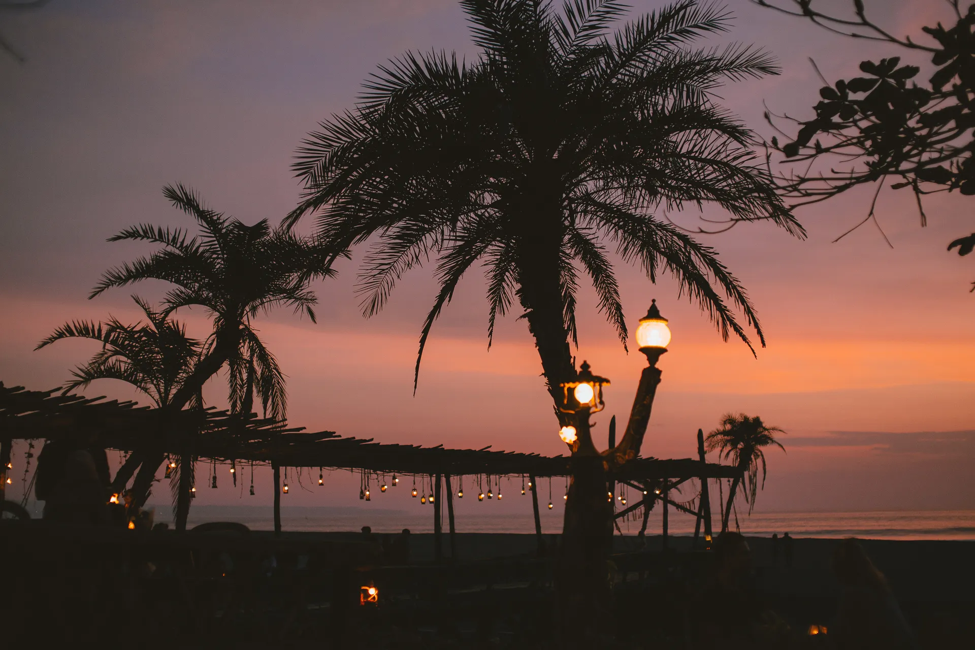 Tropical beach with palm trees at sunset, one of the best places to travel in December for warm weather