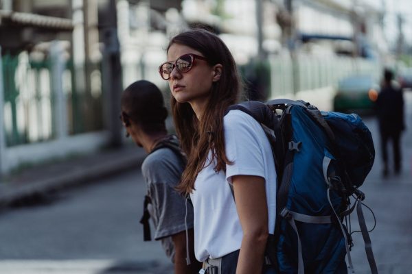Best places to travel solo in the USA, a young traveler with a backpack exploring a city street
