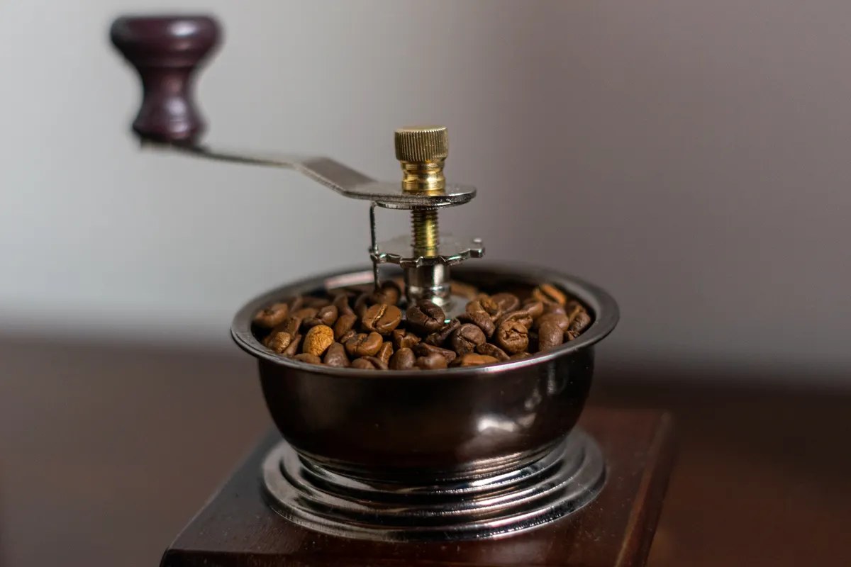 Manual coffee grinder with coffee beans — how to clean a coffee grinder