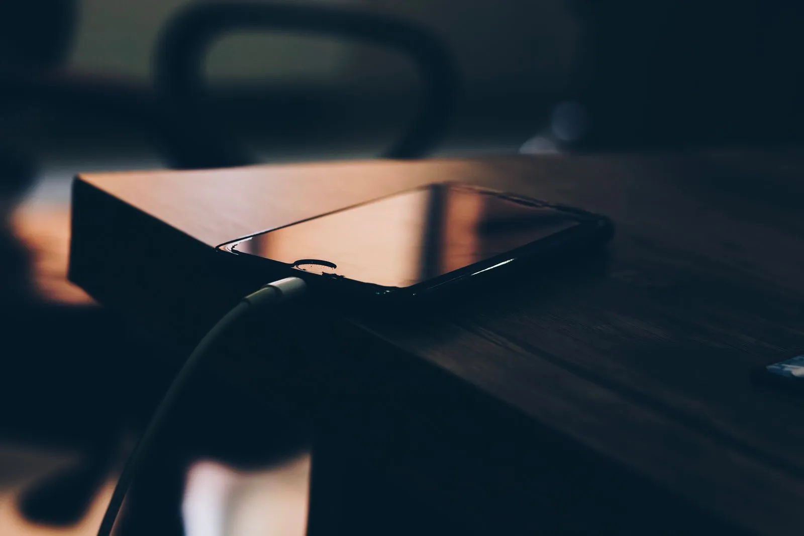 why is my phone charging so slowly - smartphone connected to charger on wooden table