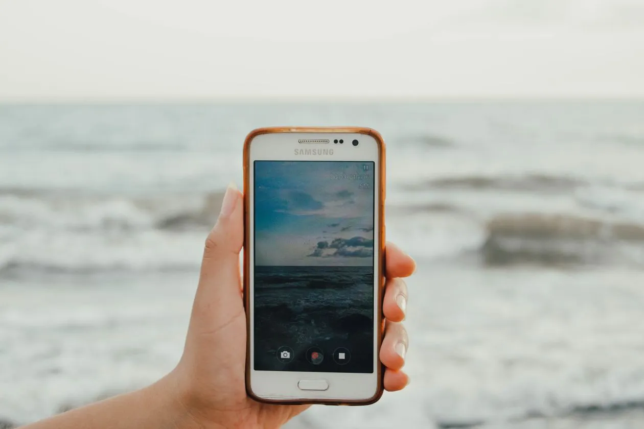 how to recover deleted photos on android without backup - hand holding android phone taking a photo