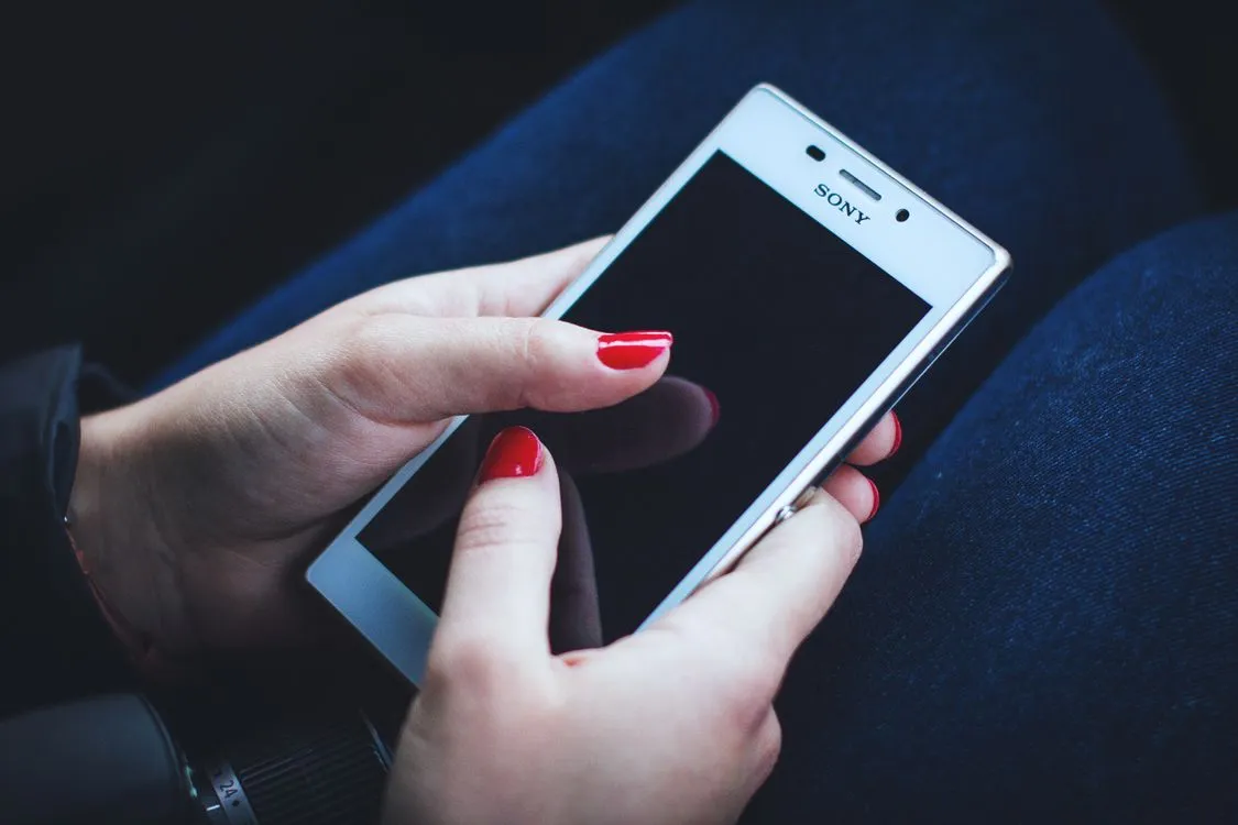 how to stop spam calls on iphone - hand holding a smartphone looking at the screen