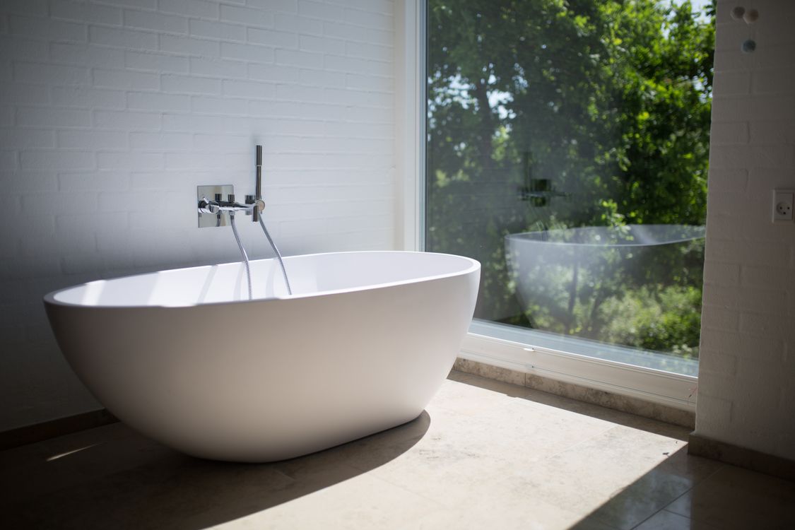 How to unclog a bathtub drain without a plunger: white bathtub in a bright bathroom
