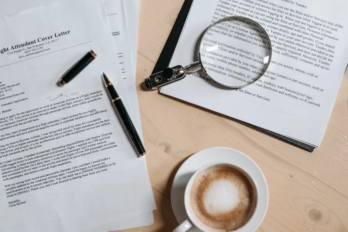 how to write a cover letter with no experience - cover letter and job application documents on a desk with coffee