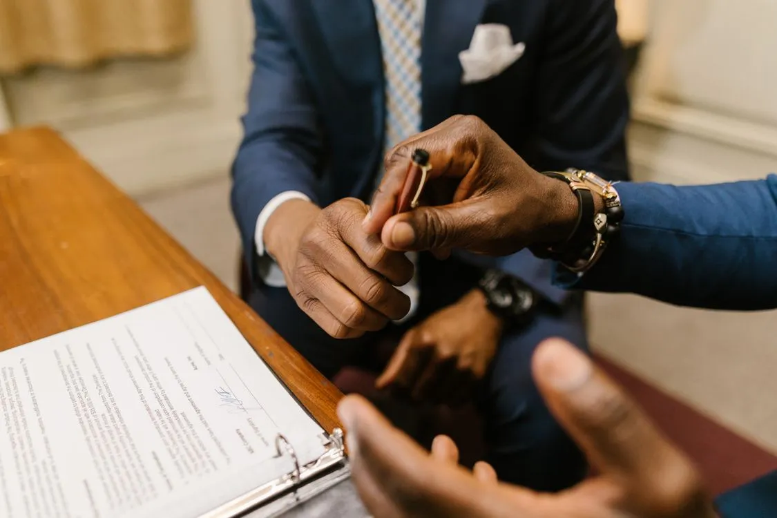 llc vs sole proprietorship pros and cons - two businessmen finalizing a contract at a desk