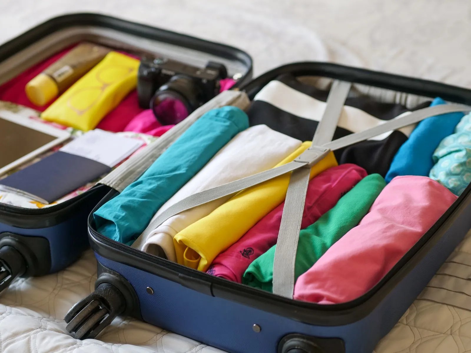 what is the 54321 packing rule - open suitcase with neatly rolled clothes packed for travel