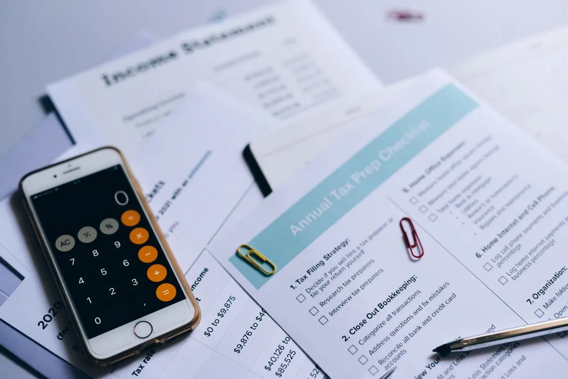 small business tax deductions checklist - tax preparation setup with documents, calculator and checklist