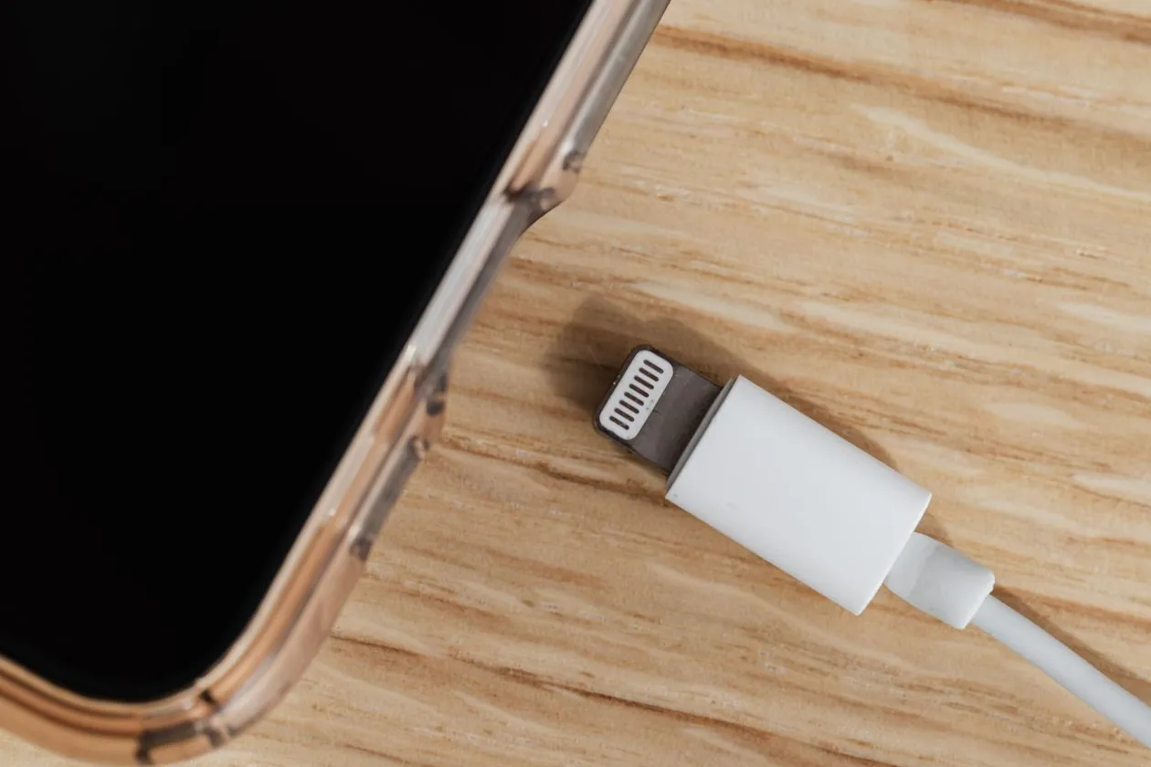 why is my iphone battery draining so fast - smartphone charging on wooden table
